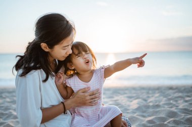 Mutsuz çocuk işaret ederek annesine gitmesini söylüyor.