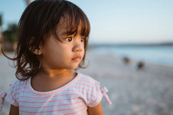 ビーチで横を見ている若い子供は — ストック写真