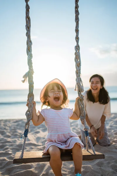 Ευτυχισμένο κοριτσάκι και μητέρα να αιωρείται στην παραλία — Φωτογραφία Αρχείου