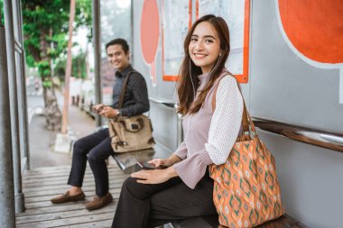 çekici genç Asyalı kadın toplu taşımayı bekliyor.