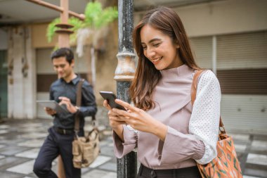 İşçiler toplu taşımayı beklerken aletlerini kullanmakla meşguller.