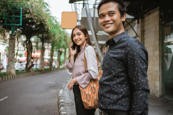 Zakenman en vrouw lopen via de stoep glimlachend naar kantoor — Stockfoto