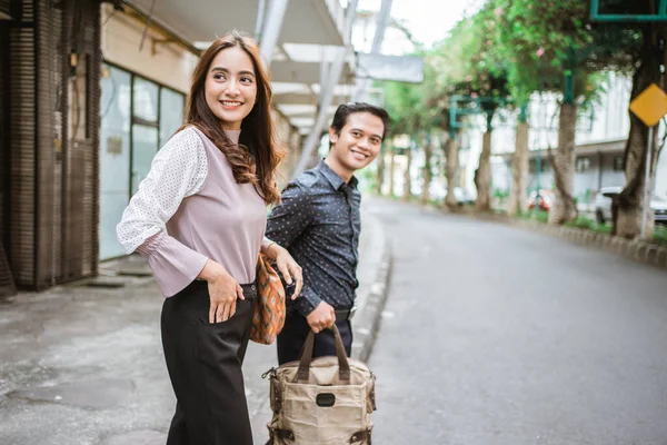 Діловий чоловік і жінка ходять на тротуарі посміхаючись йдуть в офіс — стокове фото