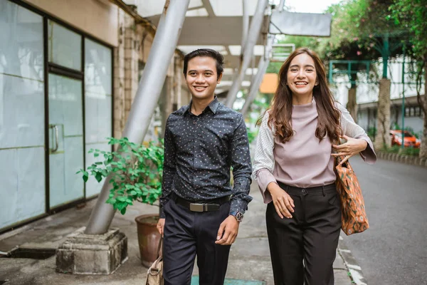 Pebisnis pria dan wanita berjalan di trotoar tersenyum pergi ke kantor — Stok Foto