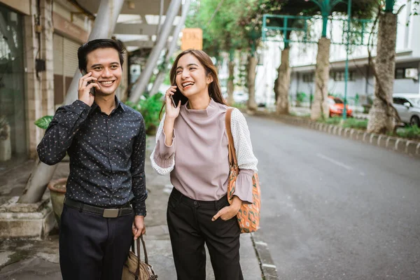 Asyalı erkek ve kadın ofise giderken telefonda konuşuyorlar. — Stok fotoğraf