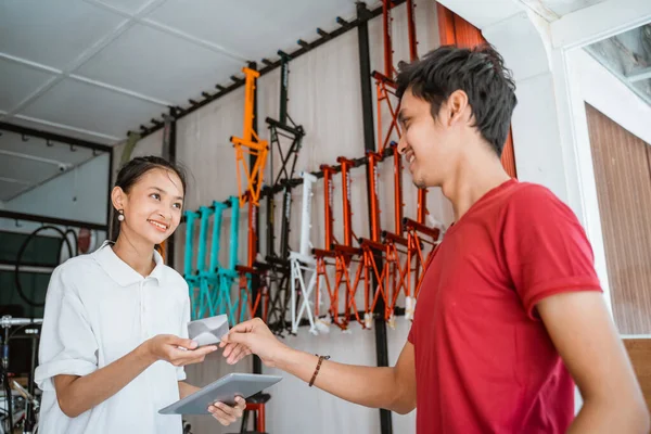 Cliente che paga con carta di credito mentre acquista una bicicletta — Foto Stock