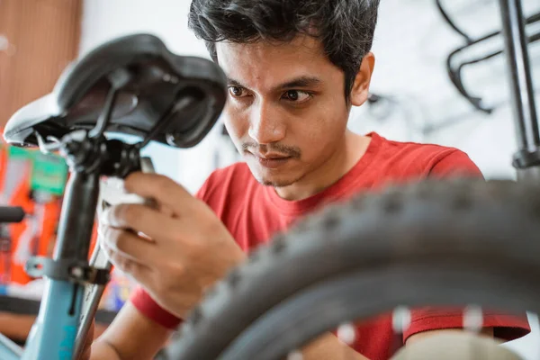 Zblízka pohledný mechanik utahování sedlové šrouby pomocí klíče — Stock fotografie