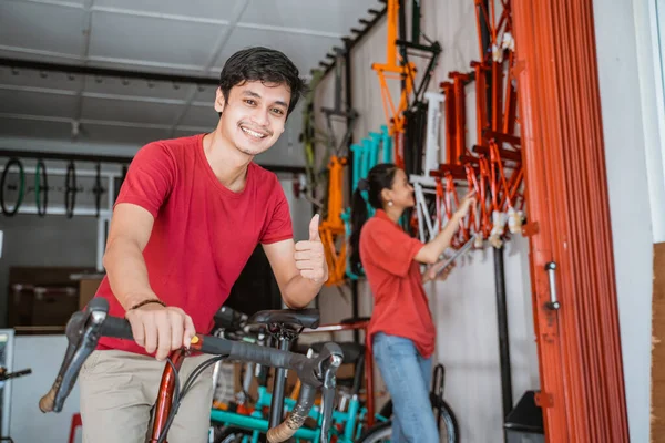 Homme souriant avec les pouces vers le haut dans le magasin de vélo — Photo