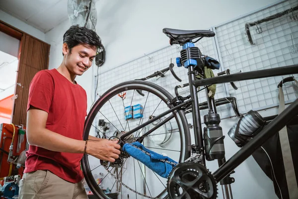 Mecánico guapo trabajando apriete el eje de la bicicleta con una llave —  Fotos de Stock