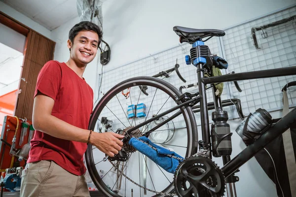 Sonrisa mecánica mientras se trabaja apriete el eje de la bicicleta con una llave inglesa —  Fotos de Stock