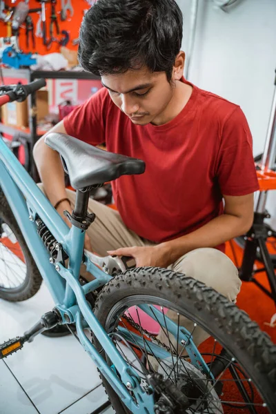 Primer plano de joven asiático mecánico instalar pedales utilizando una llave inglesa —  Fotos de Stock