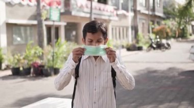 Okula ya da kampüse gitmeden önce yüz maskesi takan öğrenci