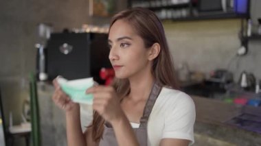 Kahve dükkanında yüz maskesi takan bir garson.