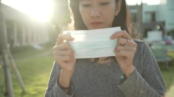 Koronavírus. Ázsiai nő orvosi eldobható maszkot visel, hogy elkerülje a vírusok. — Stock videók