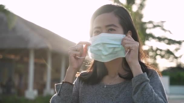 Coronavirus. Mujer asiática que se pone una máscara médica desechable para evitar virus. — Vídeo de stock