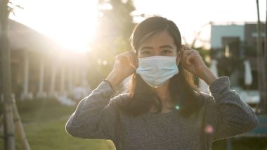 Coronavirus. Asyalı kadın virüslerden kaçınmak için tek kullanımlık tıbbi maske takıyor..