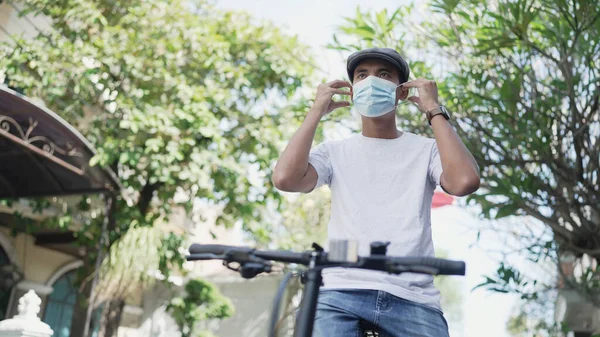 Aziatische knappe man dragen een masker tijdens het rijden zijn fiets — Stockfoto