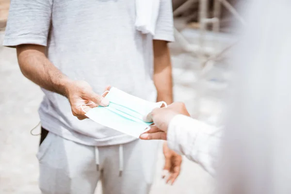 Gesto de la mano dando una máscara a alguien — Foto de Stock