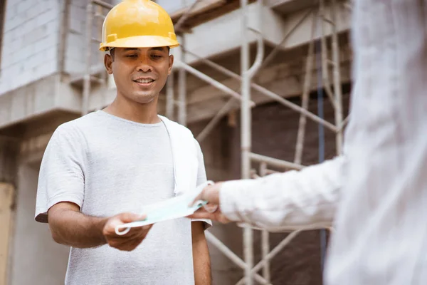 Trabajador de la construcción con una máscara mientras trabaja en un proyecto de sitio — Foto de Stock