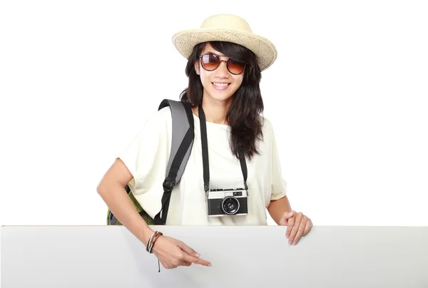 Chica joven feliz con mochila mostrando tablero en blanco —  Fotos de Stock