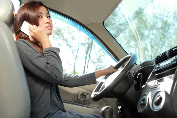 Young woman talking on the phone while driving — Stock Photo, Image
