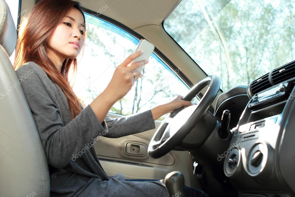 young woman texting while driving