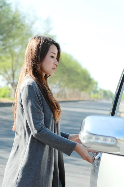 Young woman try to open the car door — Stock Photo, Image