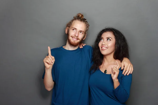 Jovem casal apontando para cima — Fotografia de Stock