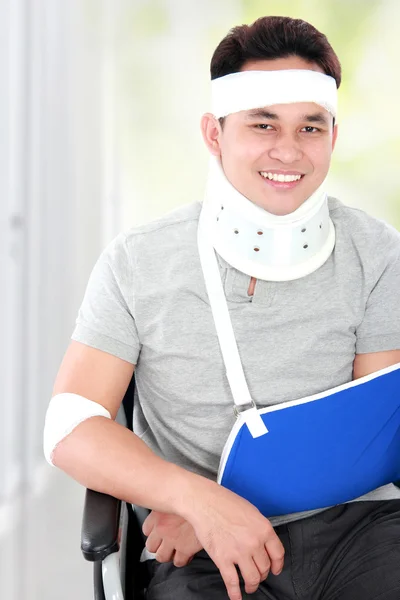 Injured young man in wheelchair still look happy — Stock Photo, Image