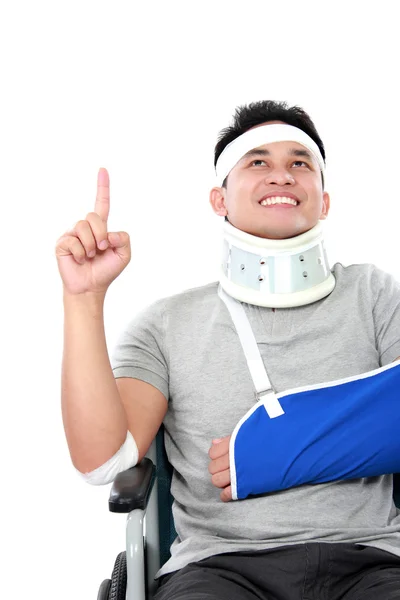 Young man with broken arm pointing upwards — Stock Photo, Image