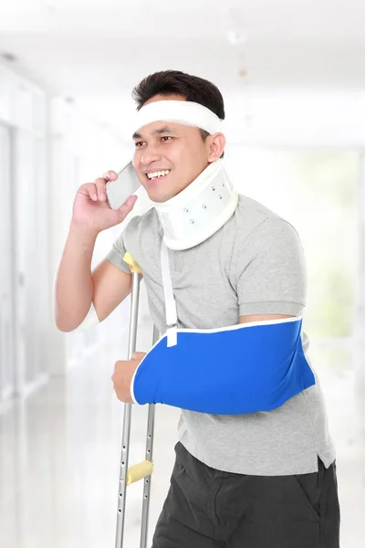 Injured young man talking on the phone — Stock Photo, Image