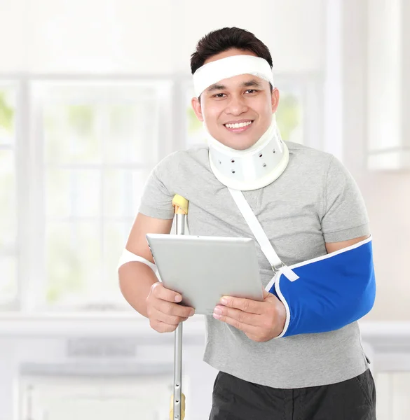 Jovem ferido segurando um tablet — Fotografia de Stock