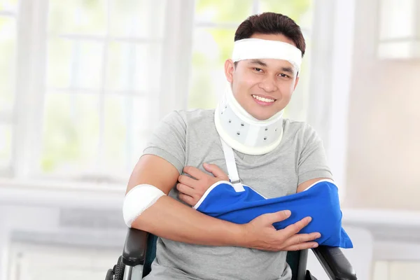 Injured young man in wheelchair with cross arm — Stock Photo, Image