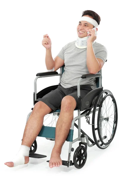 Verletzter junger Mann im Rollstuhl telefoniert — Stockfoto