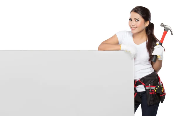 Woman holding tool standing on white board — Stock Photo, Image