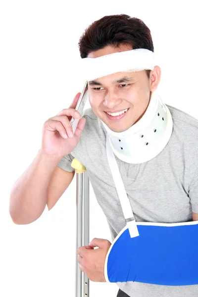 Young man with broken arm talking on the phone — Stock Photo, Image