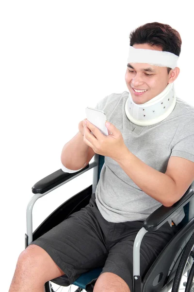 Injured young man play on his smartphone — Stock Photo, Image