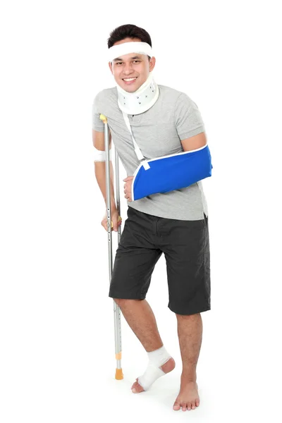 Injured young man wear arm sling and crutch — Stock Photo, Image