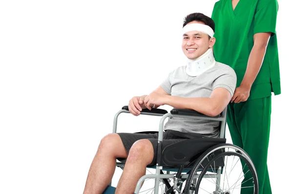 Nurse pushing young patient in wheelchair — Stock Photo, Image