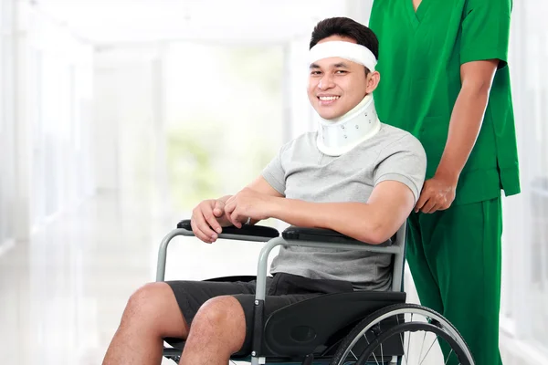 Nurse pushing young patient in wheelchair — Stock Photo, Image