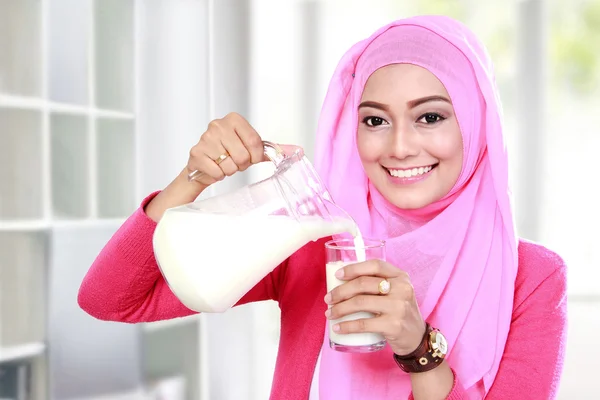 Giovane donna musulmana versando il latte in un bicchiere — Foto Stock