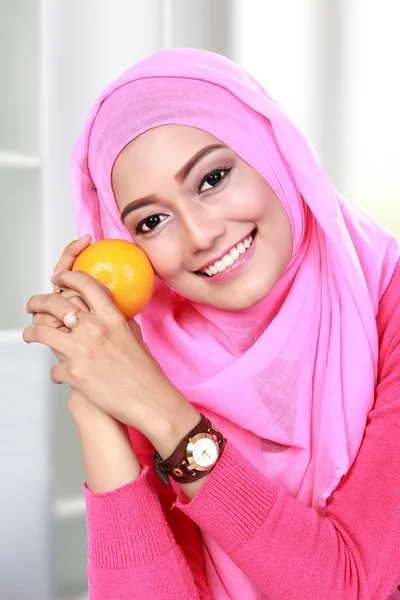 Junge muslimische Frau hält eine Orange — Stockfoto