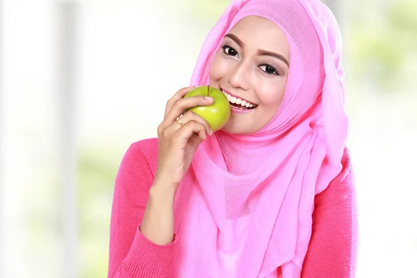 Joven musulmana mujer morder una manzana — Foto de Stock