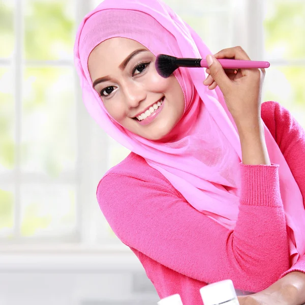 Wanita muda mengenakan jilbab menerapkan blush on — Stok Foto