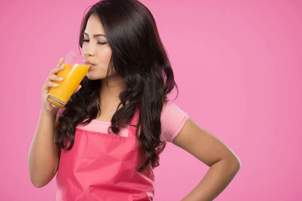 Красивая молодая жена пьет апельсиновый сок — стоковое фото