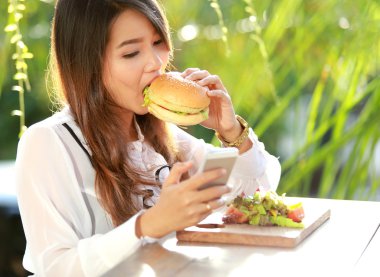 yemek sırasında manifatura onun mobilephone multitasking kadın