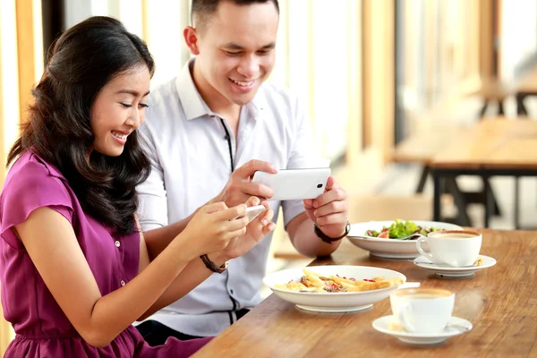 Young couple taking photos of their food — Stock Photo, Image