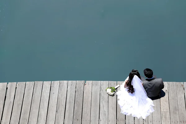 Gelin ve damat Nehri Köprüsü kenarında oturan — Stok fotoğraf