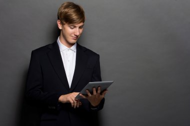 Bir tablet kullanarak siyah elbiseli genç adam