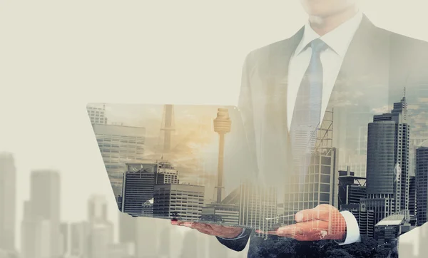 Double exposure of businessman using laptop computer — Stock Photo, Image